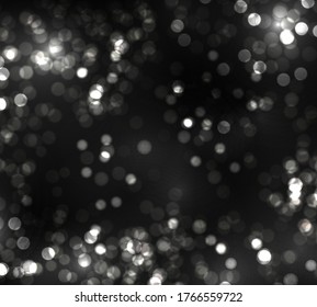 Blurred bokeh light on black background. Christmas and New Year holidays template. Abstract silver glitter defocused blinking stars and sparks. Vector EPS 10