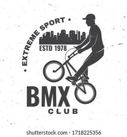 Bmx extreme sport club badge. Vector illustration. Concept for shirt, logo, print, stamp, tee with man ride on a sport bicycle. Vintage typography design with bmx cyclist and night city silhouette.