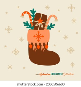 Boho Christmas stocking filled with gifts and candy cones. Bohemian Christmas socks isolated. Great symbol for Christmas cards, posters, stickers, wall art. Hand drawn in flat cartoon simple style