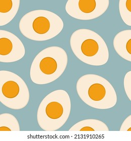 Boiled half cut eggs on blue background vector seamless pattern.