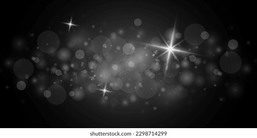 
Bokeh effect on a black background. Glitter and elegance for Christmas. The dust is white. Sparkling magical particles.