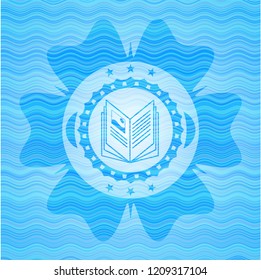 book icon inside sky blue water wave emblem.