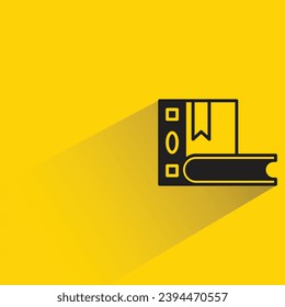 icono de libro con sombra sobre fondo amarillo