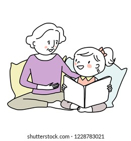 Booklover concept with mature woman telling and reading a storybook to her granddaughter. Little girl reading a storybook with her grandma. Grandmother spending happy family time with her grandkid.