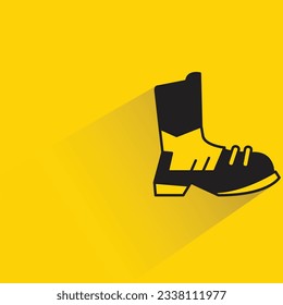 Stiefel mit Schatten auf gelbem Hintergrund