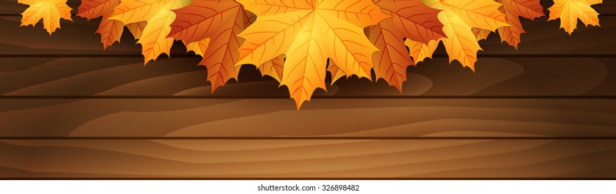 Border of autumn maples leaves on a wooden background.