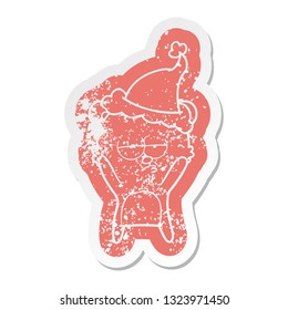 bored bear quirky cartoon distressed sticker of a wearing santa hat