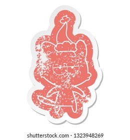 bored quirky cartoon distressed sticker of a cat wearing santa hat