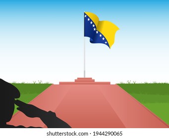 The Bosnian flag flies above the pole in the shadow of a soldier saluting the flag