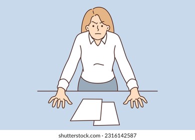 Bossy woman with displeased look stands near office desk, wanting to chastise employees or colleagues. Bossy businesswoman is frustrated with reporting errors or poor business performance