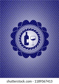 bottle and glass of wine icon inside badge with denim background