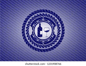 bottle and glass of wine icon inside jean or denim emblem or badge background