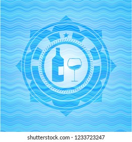 bottle and glass of wine icon inside water wave style emblem.