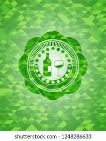 bottle and glass of wine icon inside green emblem with triangle mosaic background