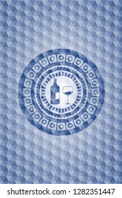bottle and glass of wine icon inside blue badge with geometric background.