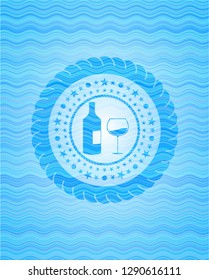 bottle and glass of wine icon inside sky blue water wave emblem.