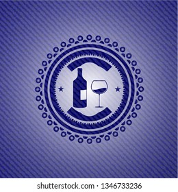 bottle and glass of wine icon inside emblem with denim high quality background
