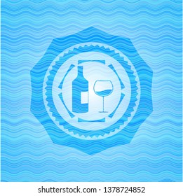 bottle and glass of wine icon inside water wave style emblem.