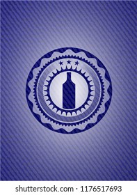 bottle icon inside emblem with jean background