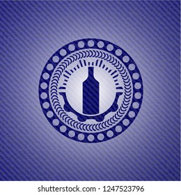 bottle icon inside emblem with jean background