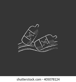 Botellas flotando en el agua. Dibujado en un icono de tiza.