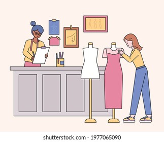 Boutique shop designers and customers looking at clothes. flat design style minimal vector illustration.