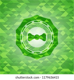 bow tie icon inside green emblem with triangle mosaic background