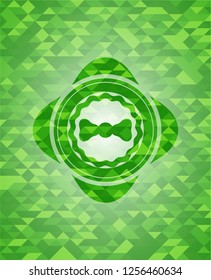 bow tie icon inside green emblem with mosaic background