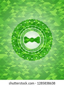bow tie icon inside green emblem with mosaic ecological style background