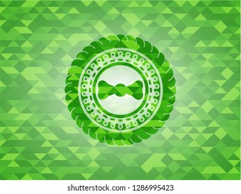 bow tie icon inside green emblem with mosaic background