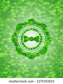 bow tie icon inside green mosaic emblem