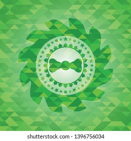 bow tie icon inside green emblem. Mosaic background