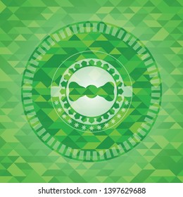 bow tie icon inside green emblem with mosaic background
