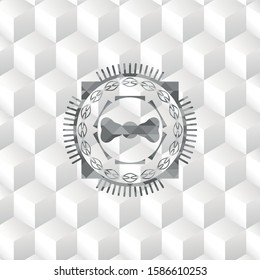 bow tie icon inside grey badge with geometric cube white background