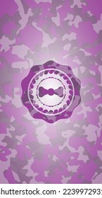 bow tie icon inside pink and purple camouflage emblem. 