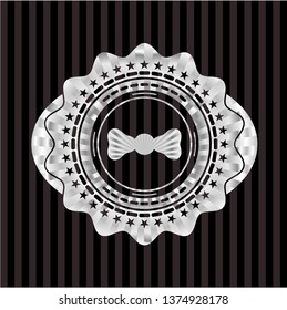 bow tie icon inside silvery emblem or badge