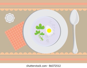 bowl of soup with a spoon on the tablecloth