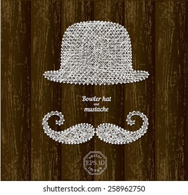 Bowler hat and mustache silhouettes made with white threads on pins on wooden background 