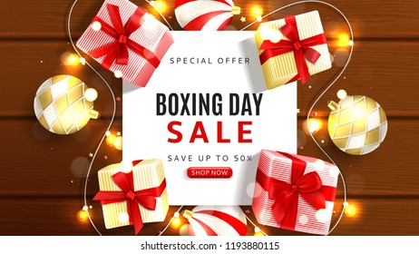 Boxing day sale web banner. Top view on realistic gift boxes and Christmas balls on rustic wooden texture. Vector illustration with confetti and effect bokeh.