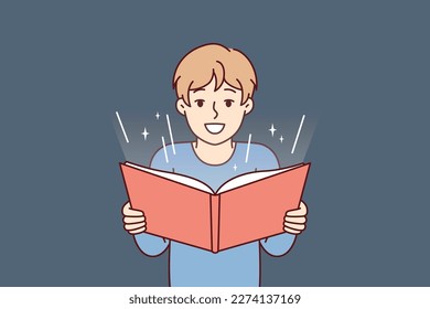 Boy before adolescence with open book in hands reads fairy tale or comics with interest. Student fulfills instructions teacher and is engaged in extracurricular activities studying material from book 