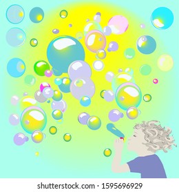 The boy blows soap bubbles on a background of the sun