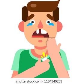 Boy with brown hair wearing a green t-shirt is missing a tooth which he is holding with one hand and with the other hand he is covering his mouth. His mouth is open and the boy is crying. 