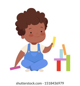 Boy is building from colorful blocks. Vector illustration on a white background.