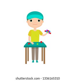 Boy building toy house or tower from lego blocks isolated against white background