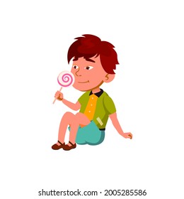 Boy Child Enjoying Sweet Lollipop Candy Vector. Asian Preteen Kid Sitting On Floor And Eating Delicious Lollipop Candy. Character Tasty Dessert, Sugary Food Flat Cartoon Illustration