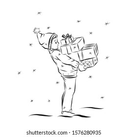 Boy with Christmas gifts stands under snowfalls.