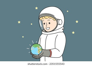 Boy dressed as astronaut is holding miniature planet earth, located in space with starry sky. Small child dreams of becoming astronaut and going on cosmos research expedition on shuttle