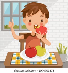 Boy eating apple.sitting at the table  eating fruit.Red apple biting.green apple in a tray placed on a table at home in the dining room.emotional mood on child's face feels good.Symbols hand thumb up.