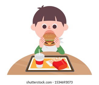 Boy eating hamburger set in fast food restaurant