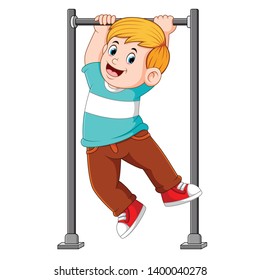 the boy is hanging and holding on the monkey bar